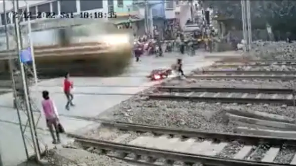 Biker escapes a major train accident while trying to cross the railway tracks. (Image courtesy: Twitter/@rajtoday)